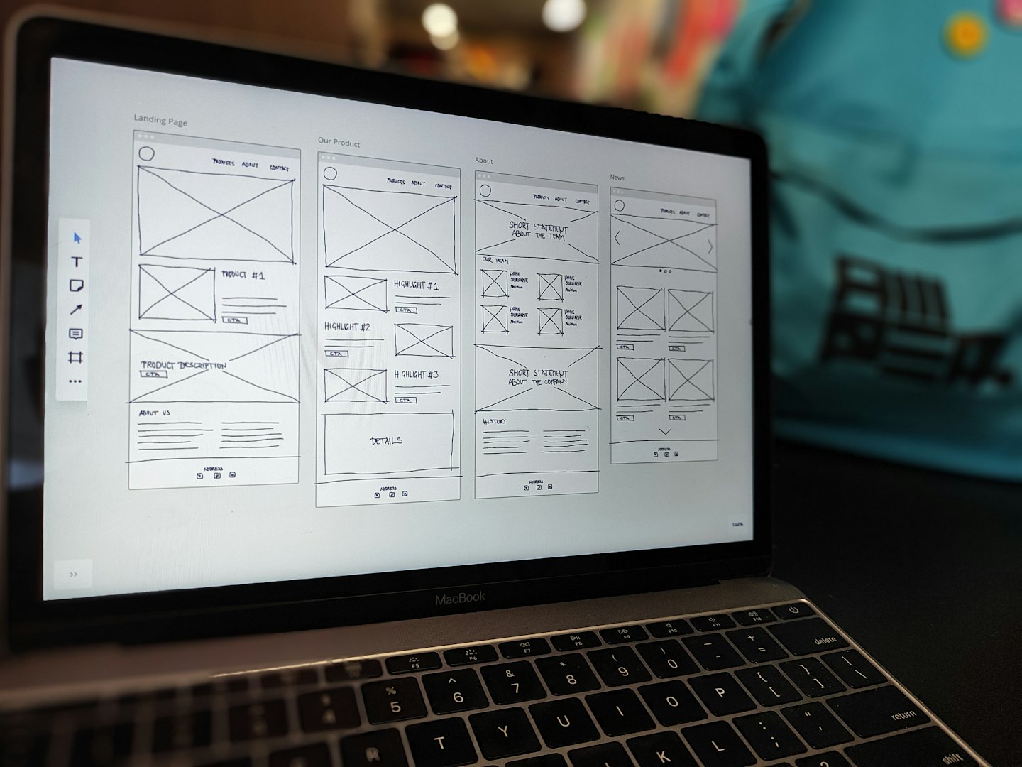 Laptop screen shows black and white wireframes for website design.